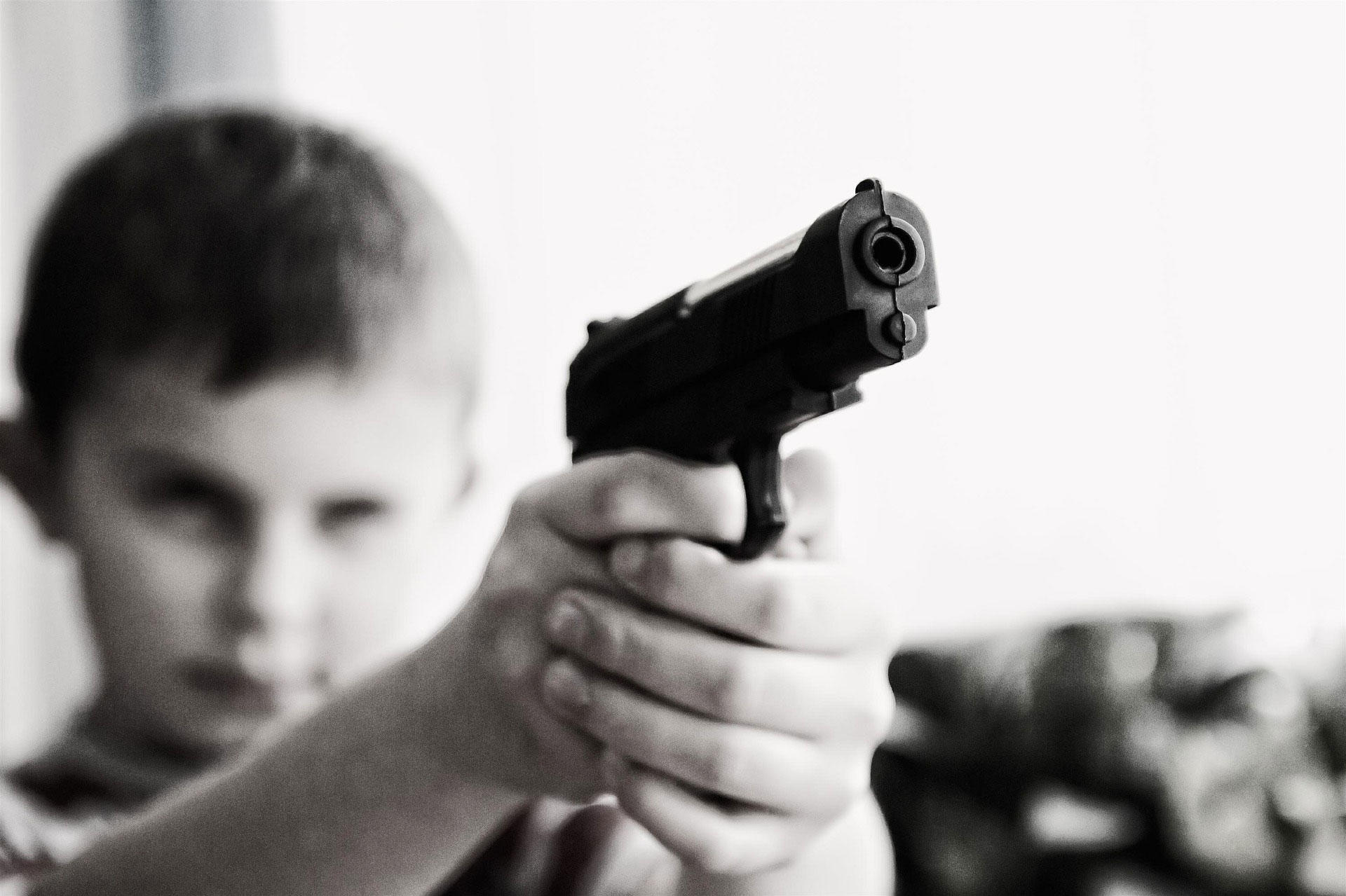 crianA§a com uma arma Foto crianA§a com uma arma